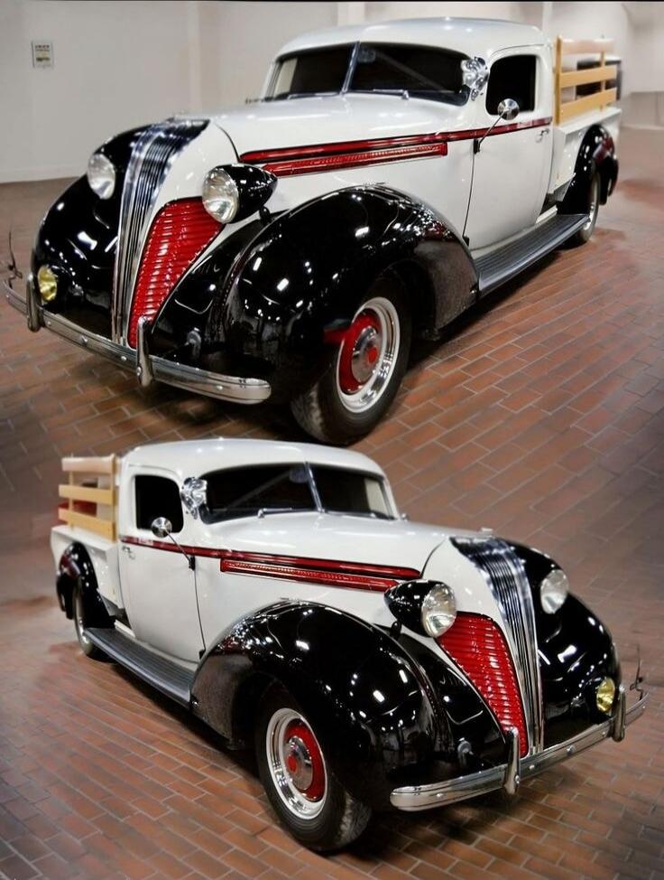 A classic vintage car (1930s style) with black fenders and white body.