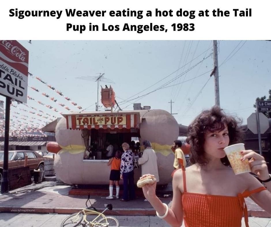 Sigourney Weaver eating a hot dog at the Tail Pup in Los Angeles 1983 o T