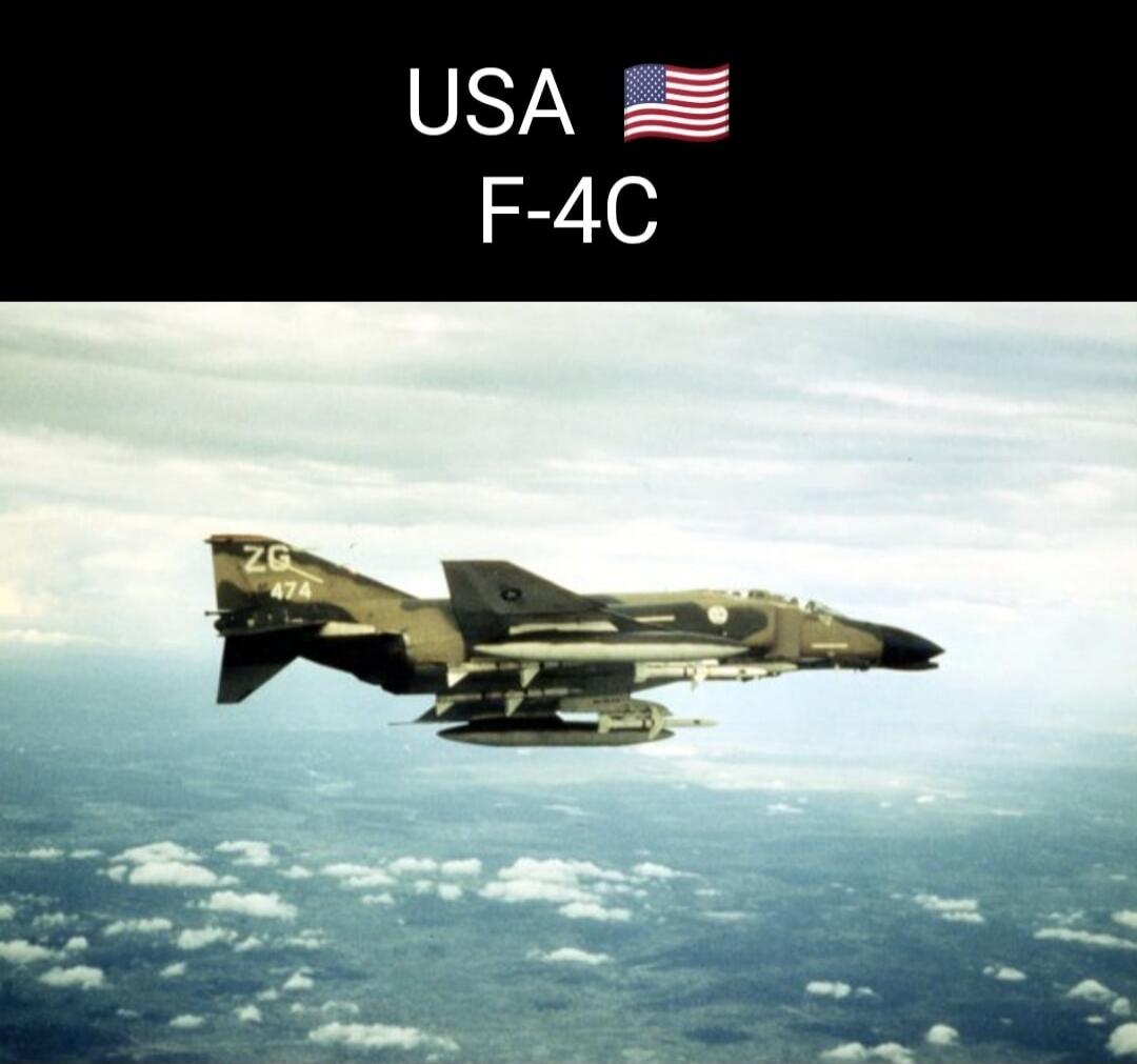 USA F-4C. An F-4C Phantom II fighter jet, a military aircraft from the United States, is flying in the sky above clouds and land.
