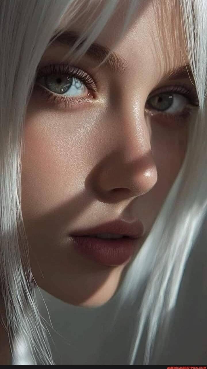 Close-up portrait of a woman with pale skin, silver hair, and blue-green eyes.
