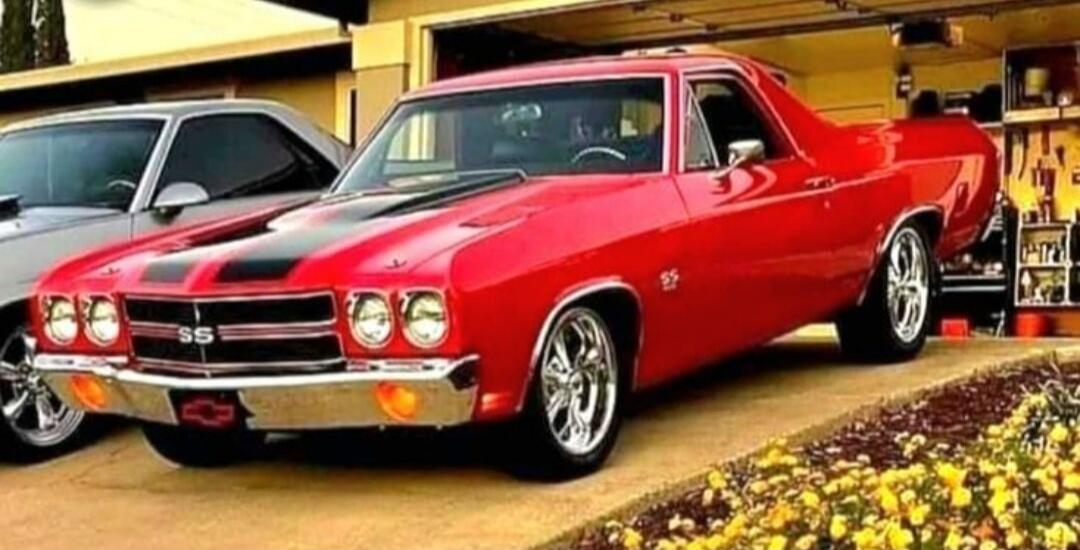 Red classic Chevrolet El Camino SS with chrome bumper and black racing stripes.