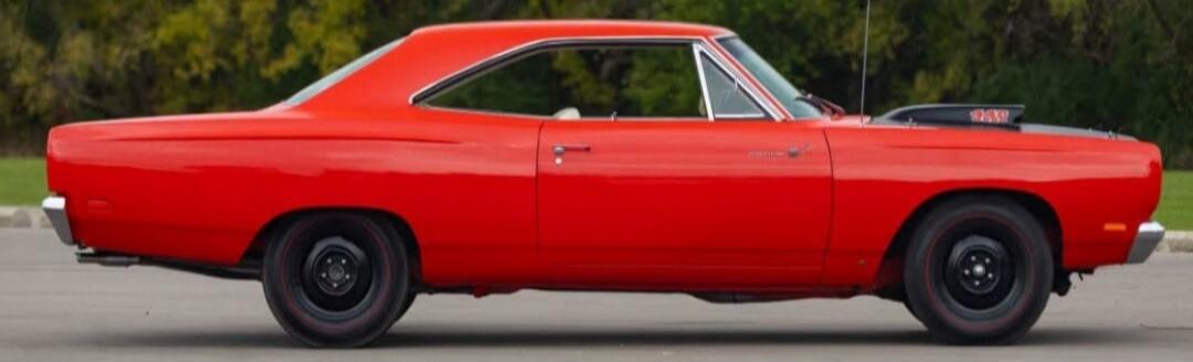 Red classic muscle car parked on the asphalt