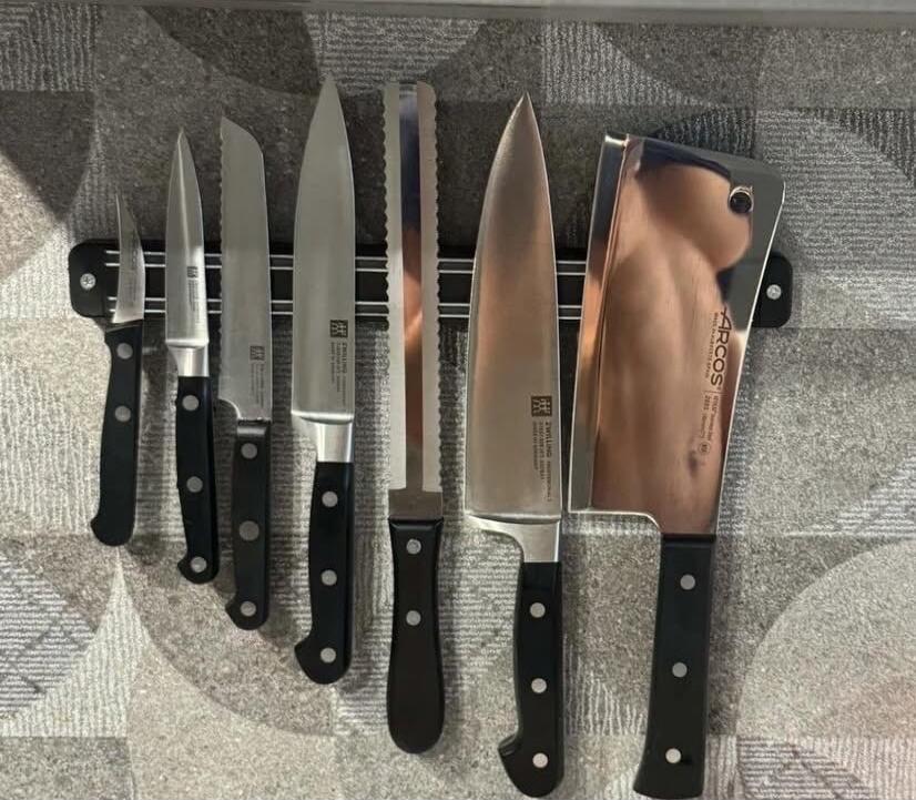 Collection of kitchen knives on a knife rack.