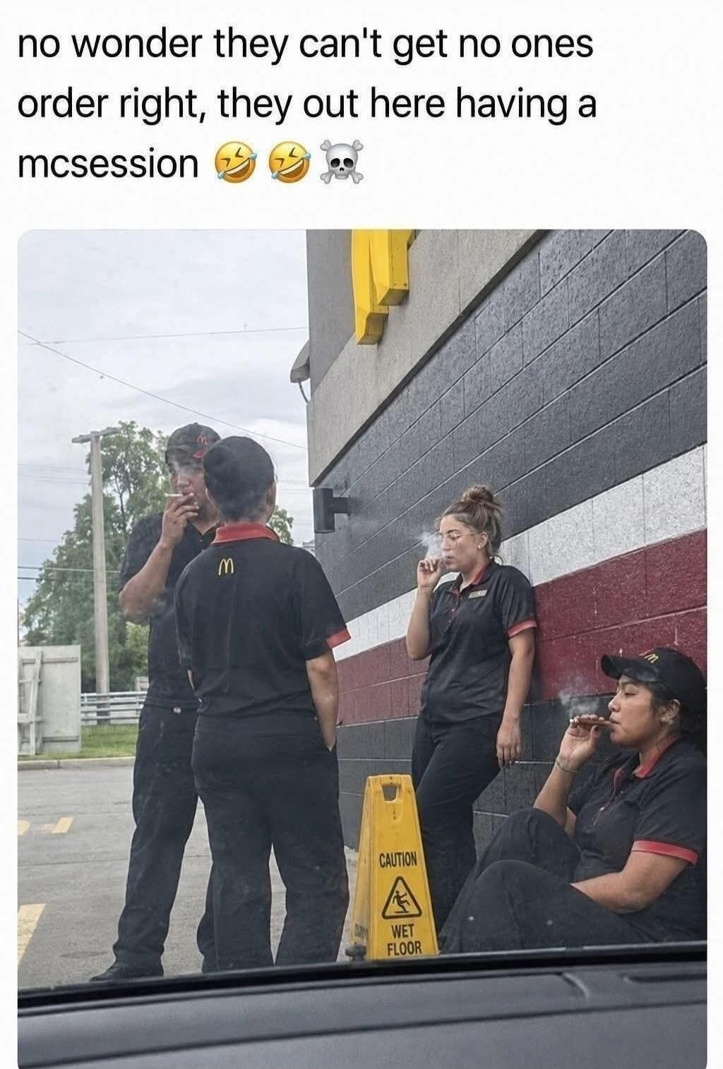 no wonder they can't get no ones order right, they out here having a mcsession 😂 😂 💀. Several McDonald's employees are seen outside, some smoking cigarettes or what appears to be a blunt, during what the text calls a 'mcsession'.