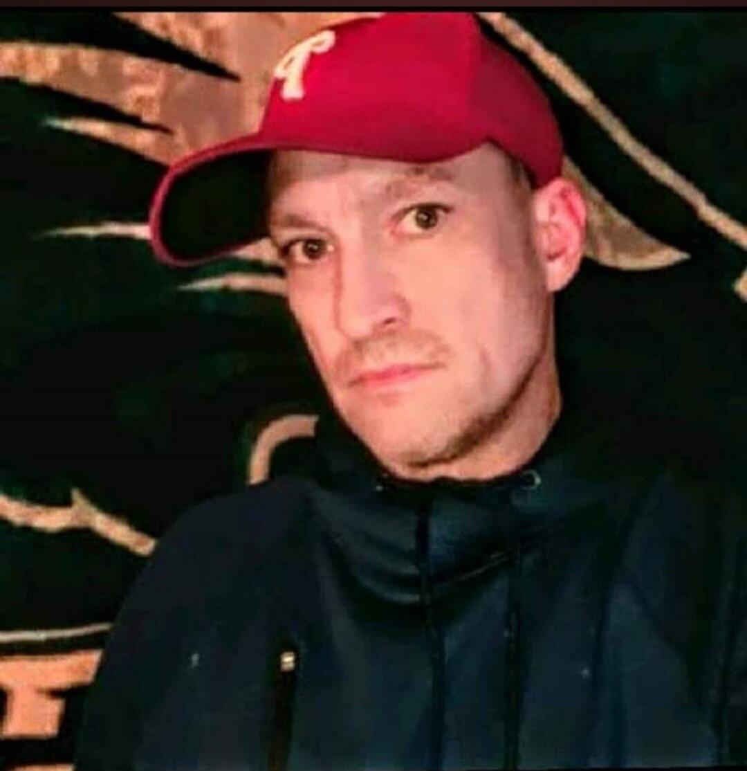 A man wearing a red baseball cap with a white 'P' logo.