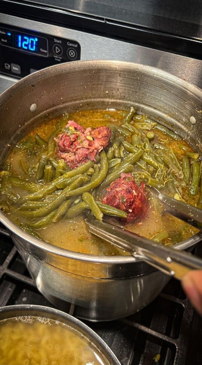 120 Start Cancel Timer. A pot of green beans with meat (likely ham hocks) cooking on a stove. Another pot with pasta is partially visible.
