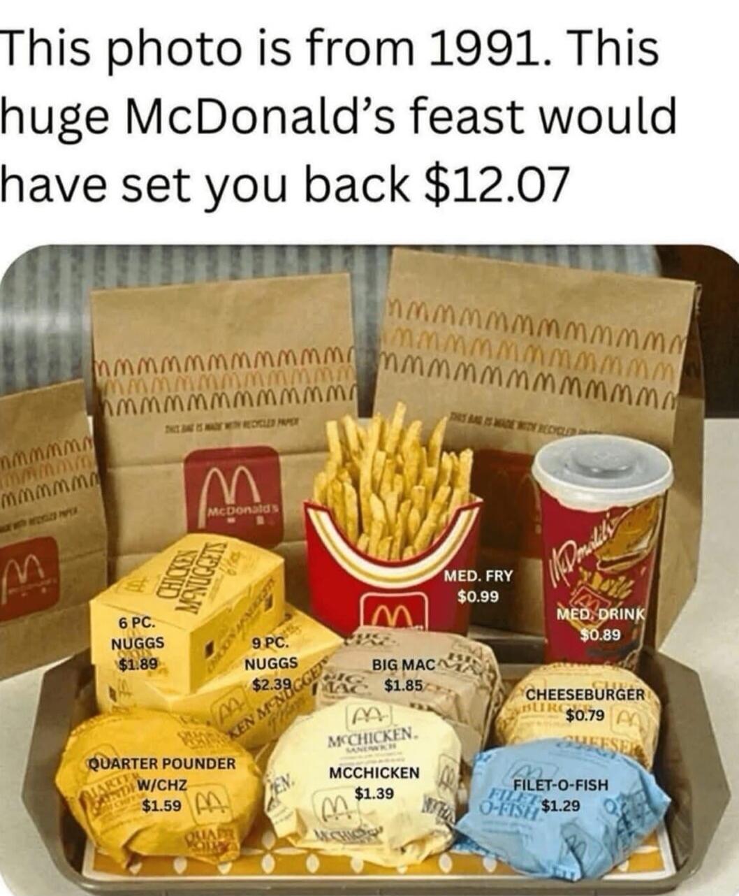 This photo is from 1991. This huge McDonald's feast would have set you back $12.07. Items shown with prices: 6 PC. NUGGS $1.89, 9 PC. NUGGS $2.39, BIG MAC $1.85, MCCHICKEN $1.39, QUARTER POUNDER W/CHZ $1.59, MED. FRY $0.99, MED. DRINK $0.89, CHEESEBURGER $0.79, FILET-O-FISH $1.29.
