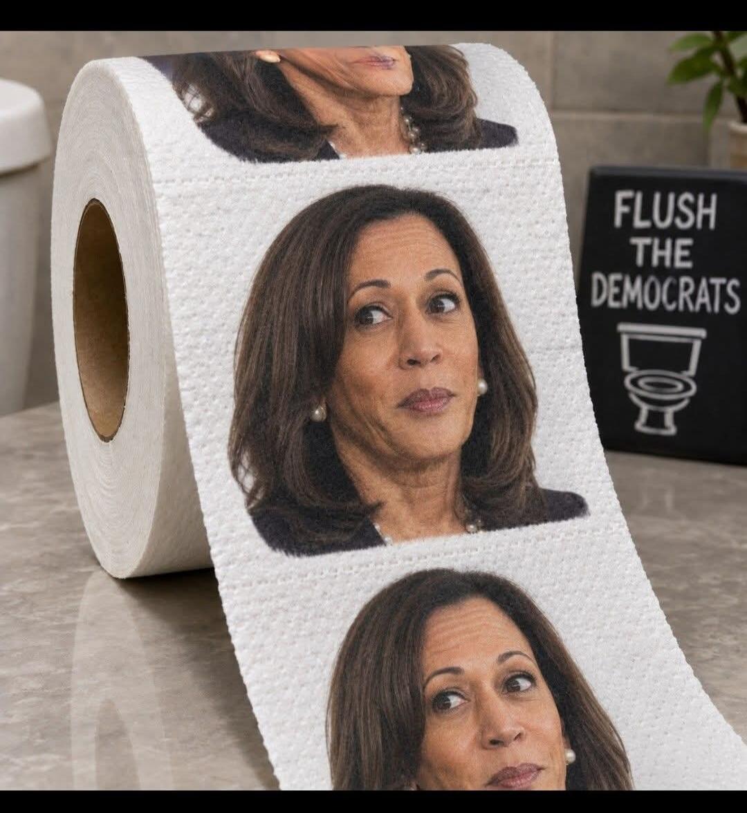 Kamala Harris's face printed on toilet paper. A sign in the background reads 'FLUSH THE DEMOCRATS' with a toilet icon.