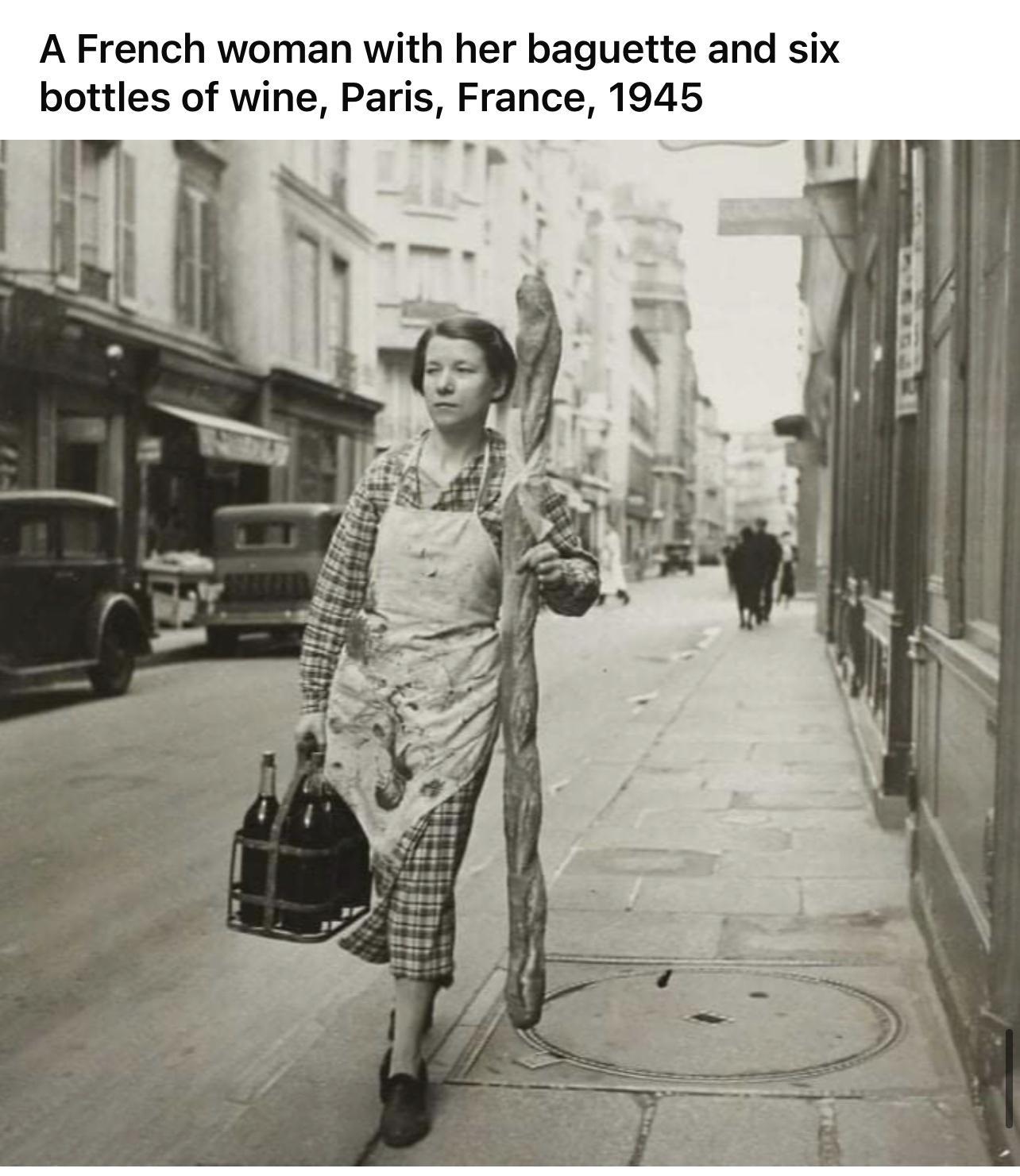 A French woman with her baguette and six bottles of wine Paris France 1945