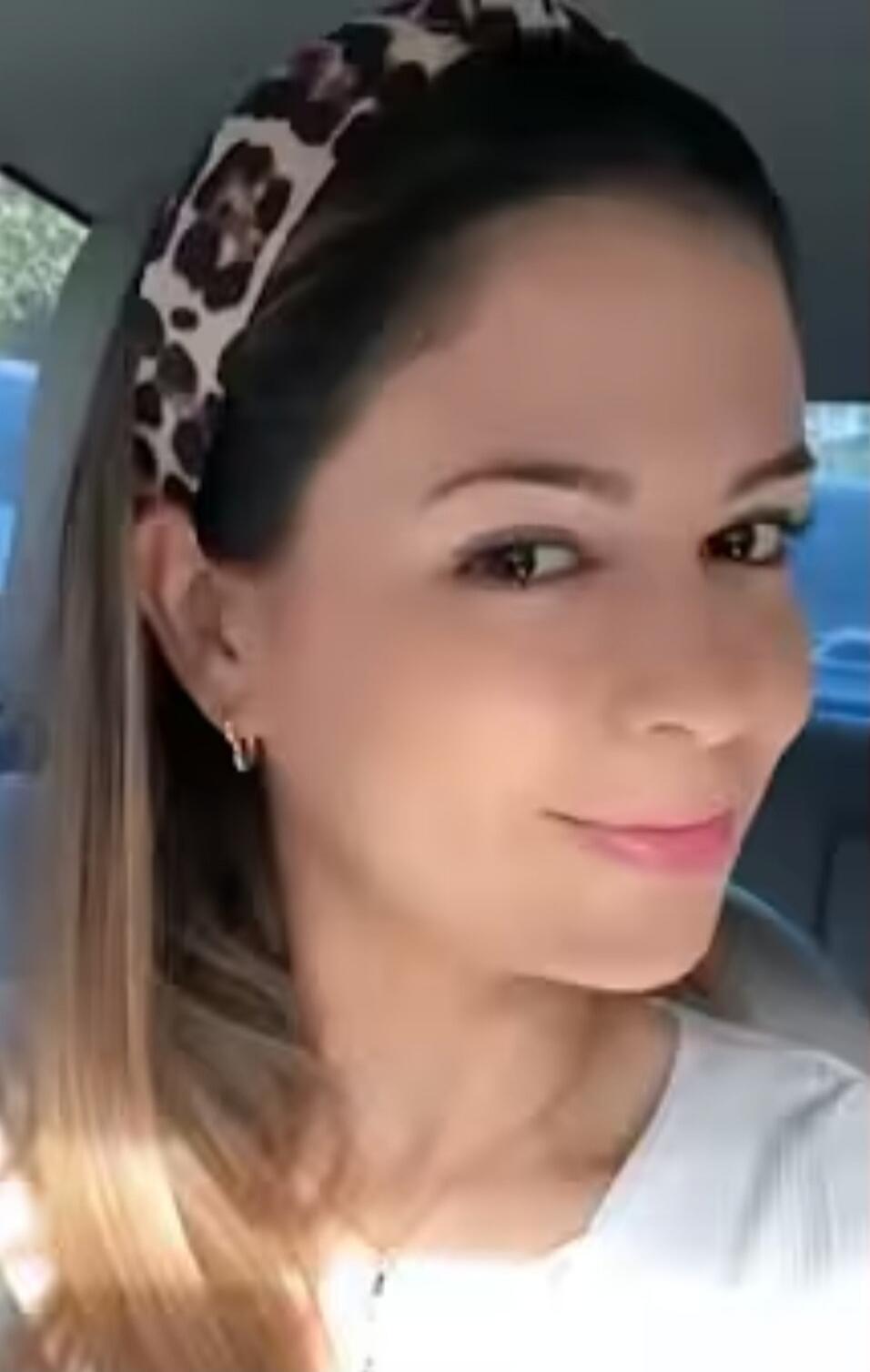 A woman in a car wearing a leopard print headband.