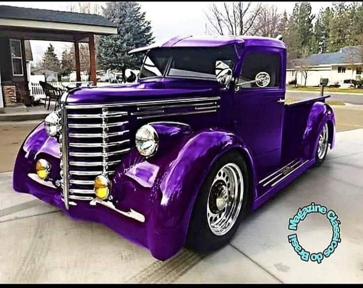 A custom purple vintage pickup truck parked on a driveway.