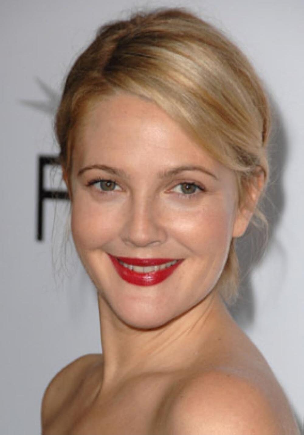 A close-up portrait of a smiling blonde woman with red lipstick.