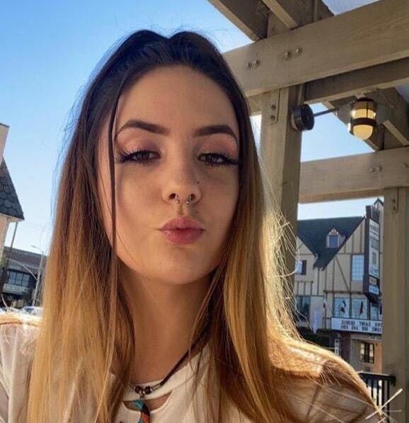 A young woman taking a selfie outdoors.