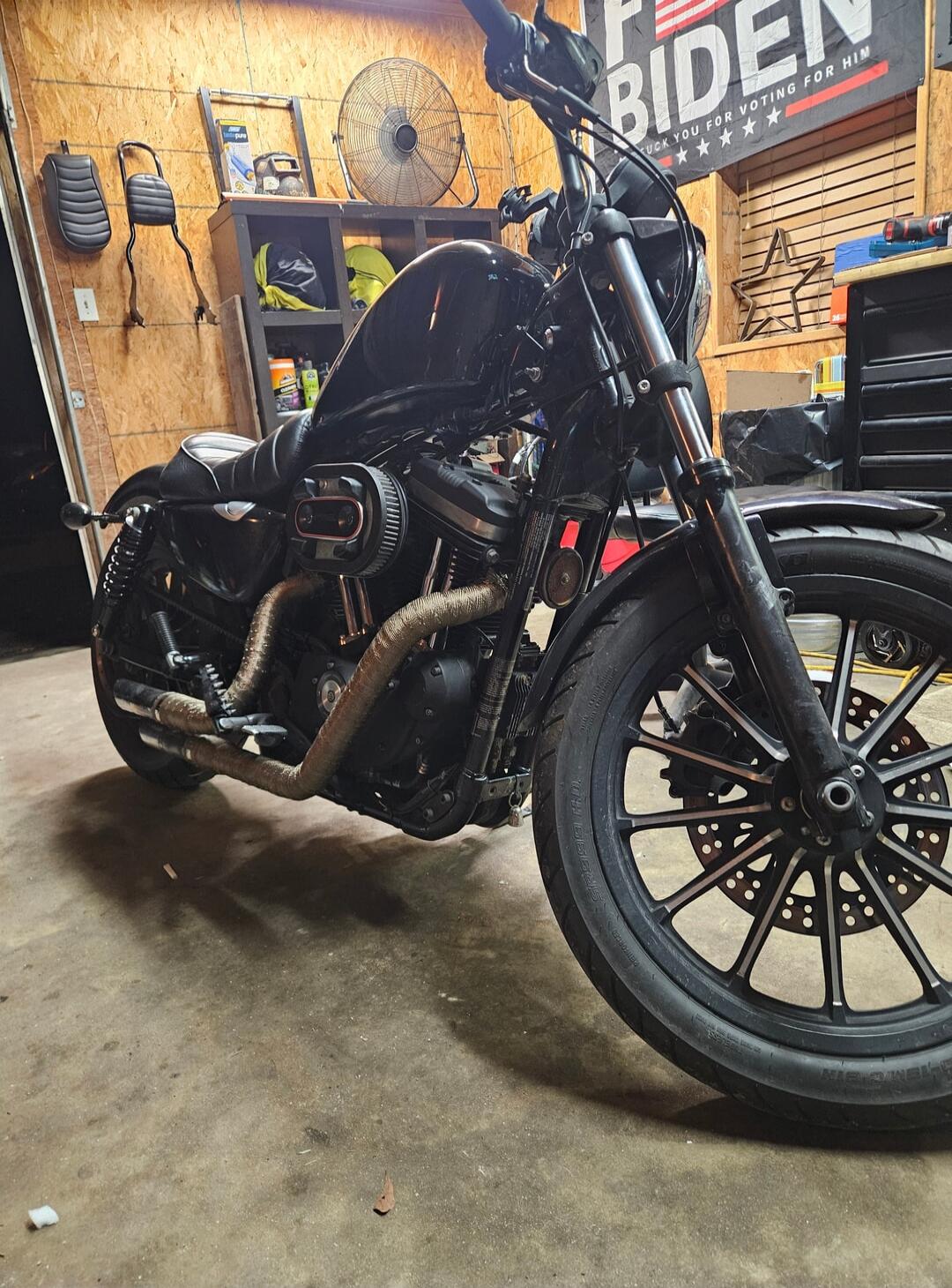 BIDEN banner in the background. Motorcycle in a garage workshop.