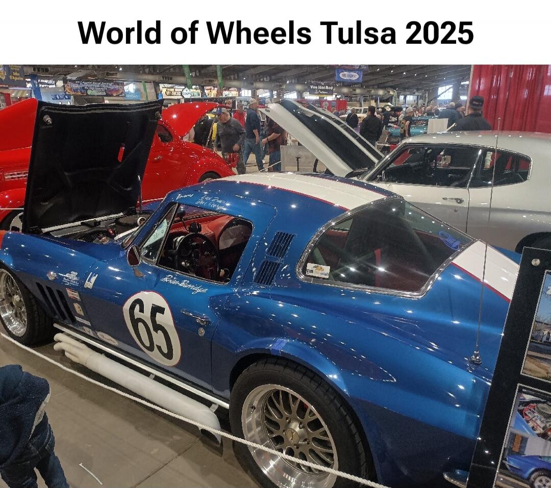 World of Wheels Tulsa 2025. A blue classic car with the number 65 and racing stripes is displayed at a car show.