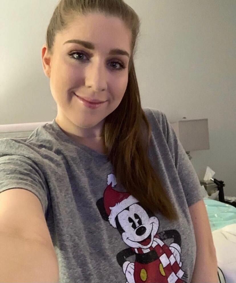 Mickey Mouse wearing a Santa hat and scarf on a gray shirt.