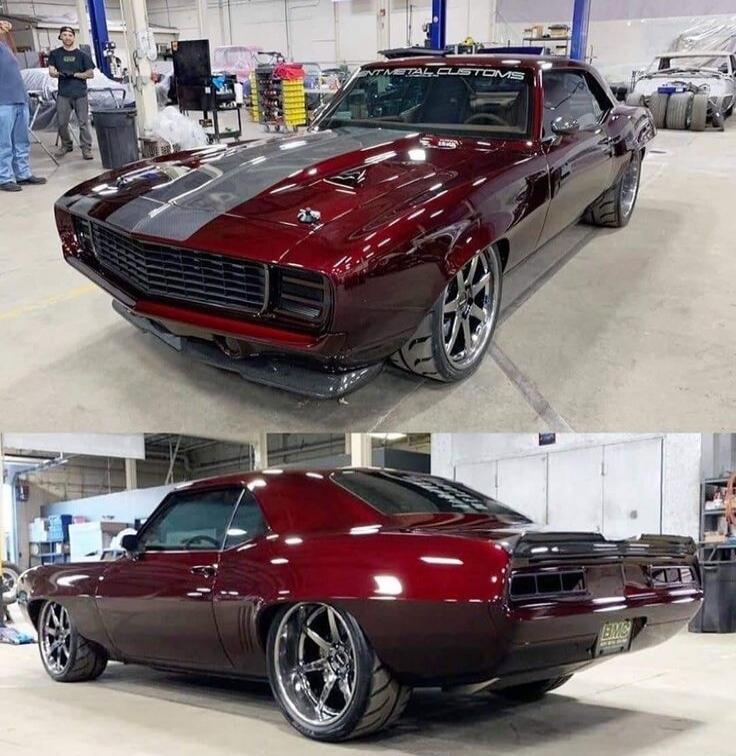 Red custom muscle car with gray racing stripe in a workshop; front and rear views.