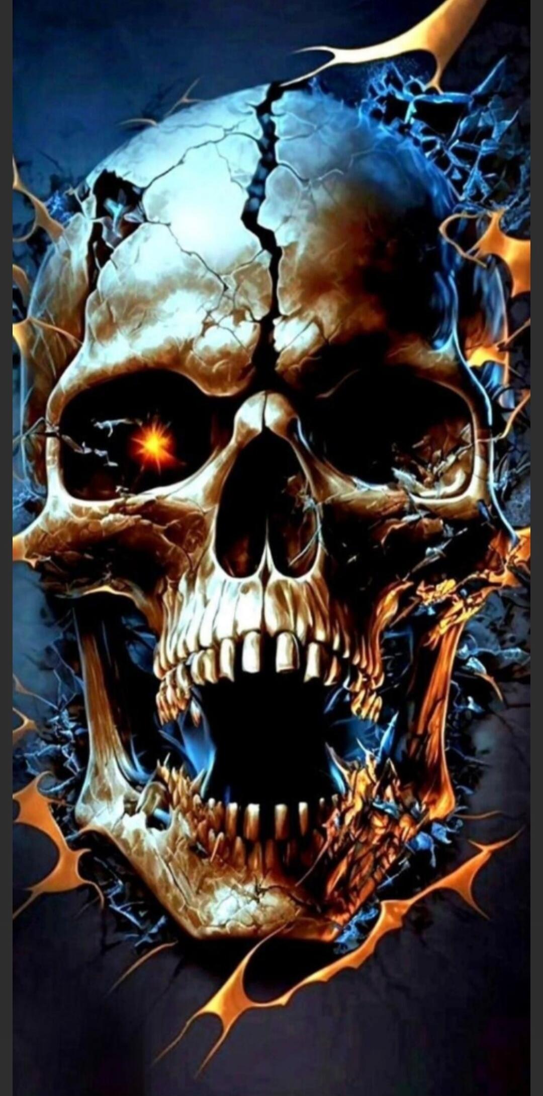 The image shows a close-up of a skull with a fiery, cracked appearance. The skull is rendered in a dark, dramatic style with glowing orange and blue accents. The eye sockets are dark, with one socket containing a bright, star-like orange glow. The teeth are sharp and exposed, and the overall impression is one of intensity and danger.