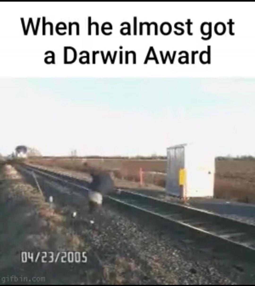 When he almost got a Darwin Award. A person is running on train tracks with a train approaching in the distance. The image also shows the date 04/23/2005.
