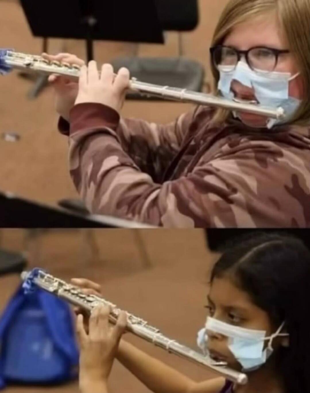 People playing flutes with face masks cut out around the mouth area to accommodate the instrument.