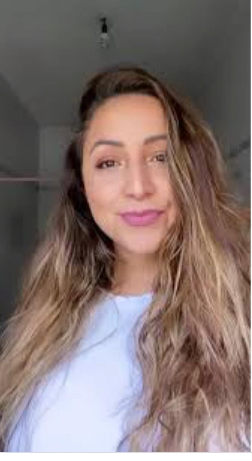 Portrait of a smiling woman with long wavy hair.