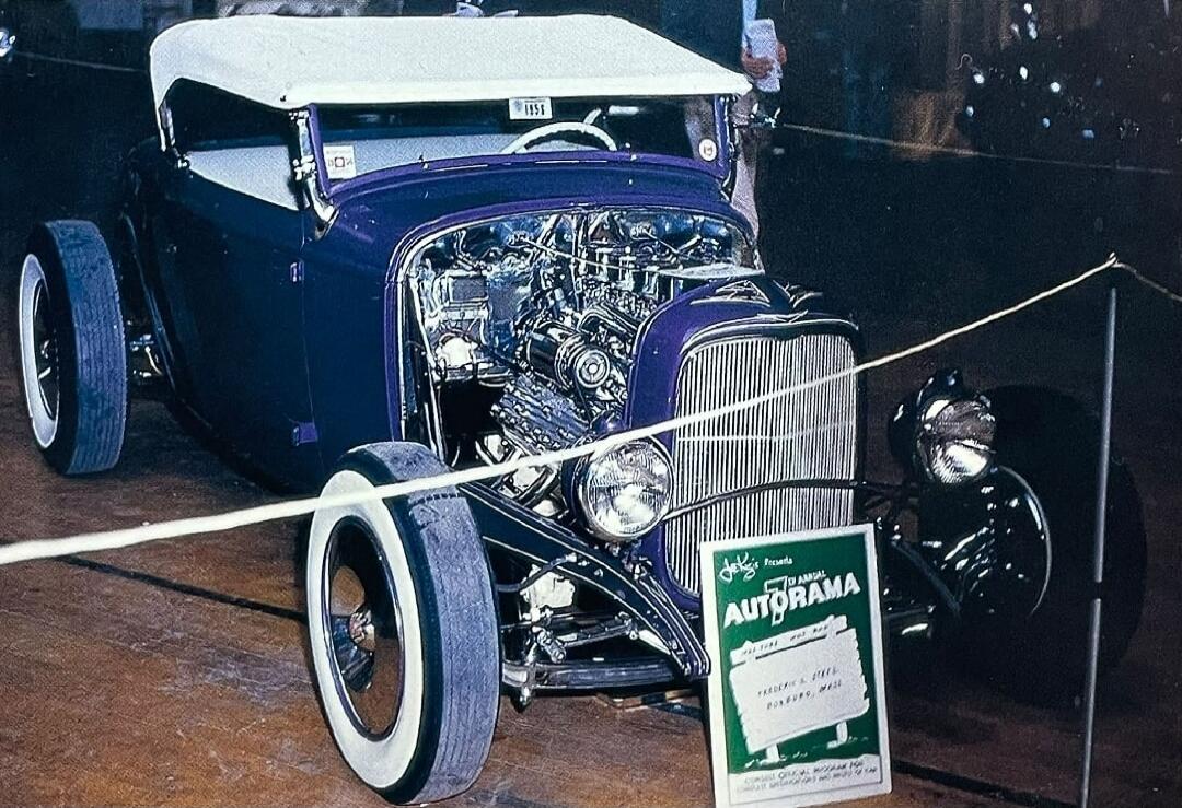 1958 Jalopy's Presents 17th ANNUAL AUTORAMA 1932 FORD HOT ROD FREDERICK A. STEELE BOXBORO, MASS. A custom-built purple hot rod with a white convertible top and an exposed chrome engine is on display at a car show, behind a rope barrier.