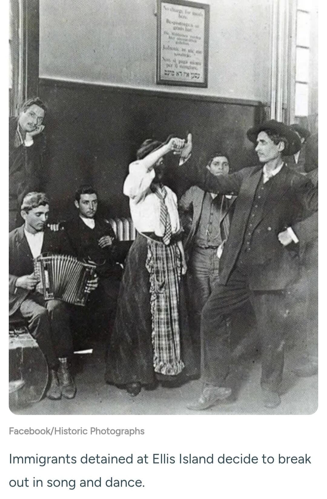 Immigrants detained at Ellis Island decide to break out in song and dance. Sign on wall: No charge for meals here. Be-spodingen at gratis hot. Non si paga niente per i mangiari. כך אין רעב כאן (There is no hunger here).