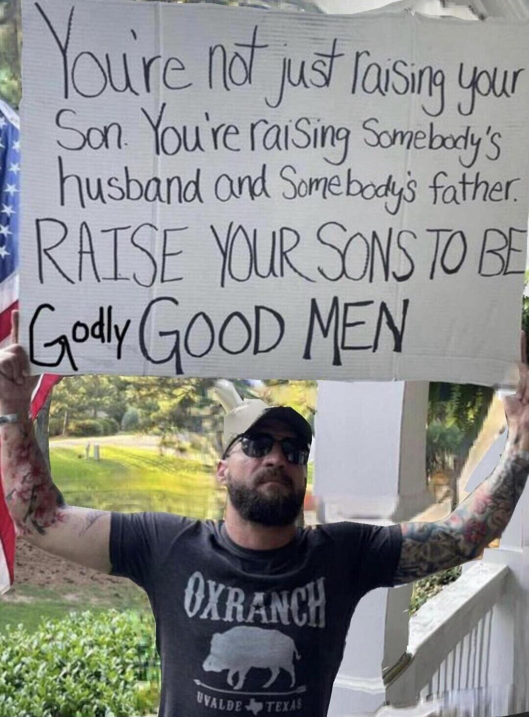 You're not just raising your Son. You're raising Somebody's husband and Somebody's father. RAISE YOUR SONS TO BE Godly GOOD MEN. The man is wearing a t-shirt with 'OXRANCH UVALDE TEXAS' printed on it, and an American flag is visible in the background.
