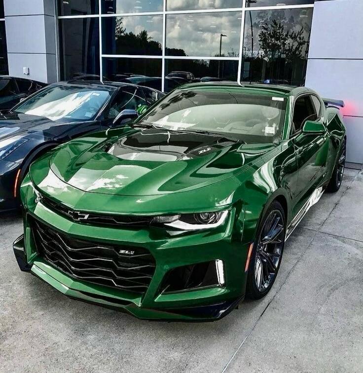 Green Chevrolet Camaro parked outside dealership