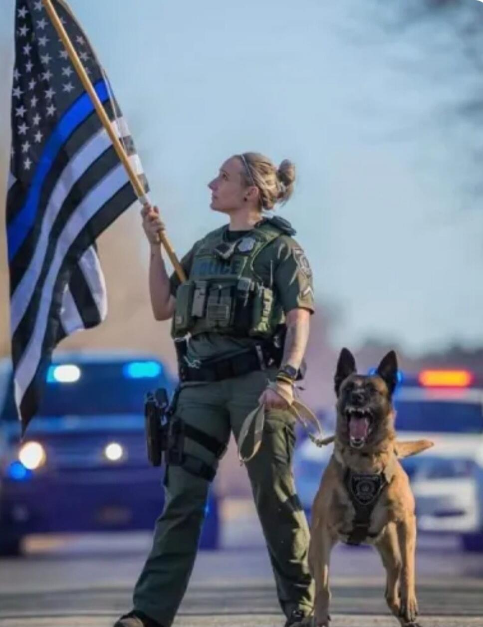 POLICE. A Thin Blue Line flag is held by the officer.