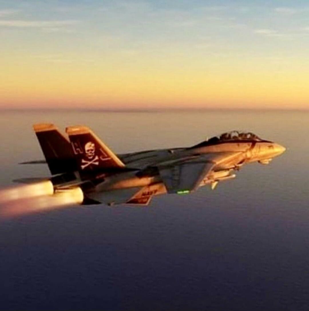 An F-14 Tomcat fighter jet, adorned with a skull and crossbones emblem on its tail, soars over the ocean during golden hour, leaving a fiery trail from its afterburners. The word 