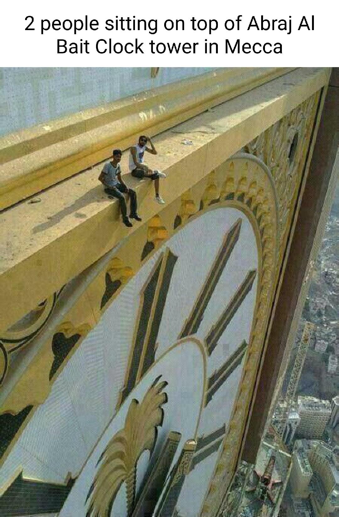 2 people sitting on top of Abraj Al Bait Clock tower in Mecca