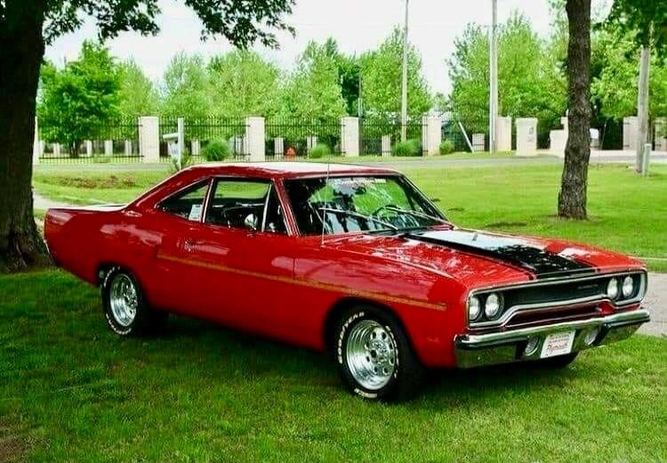 Red vintage car parked on grass.