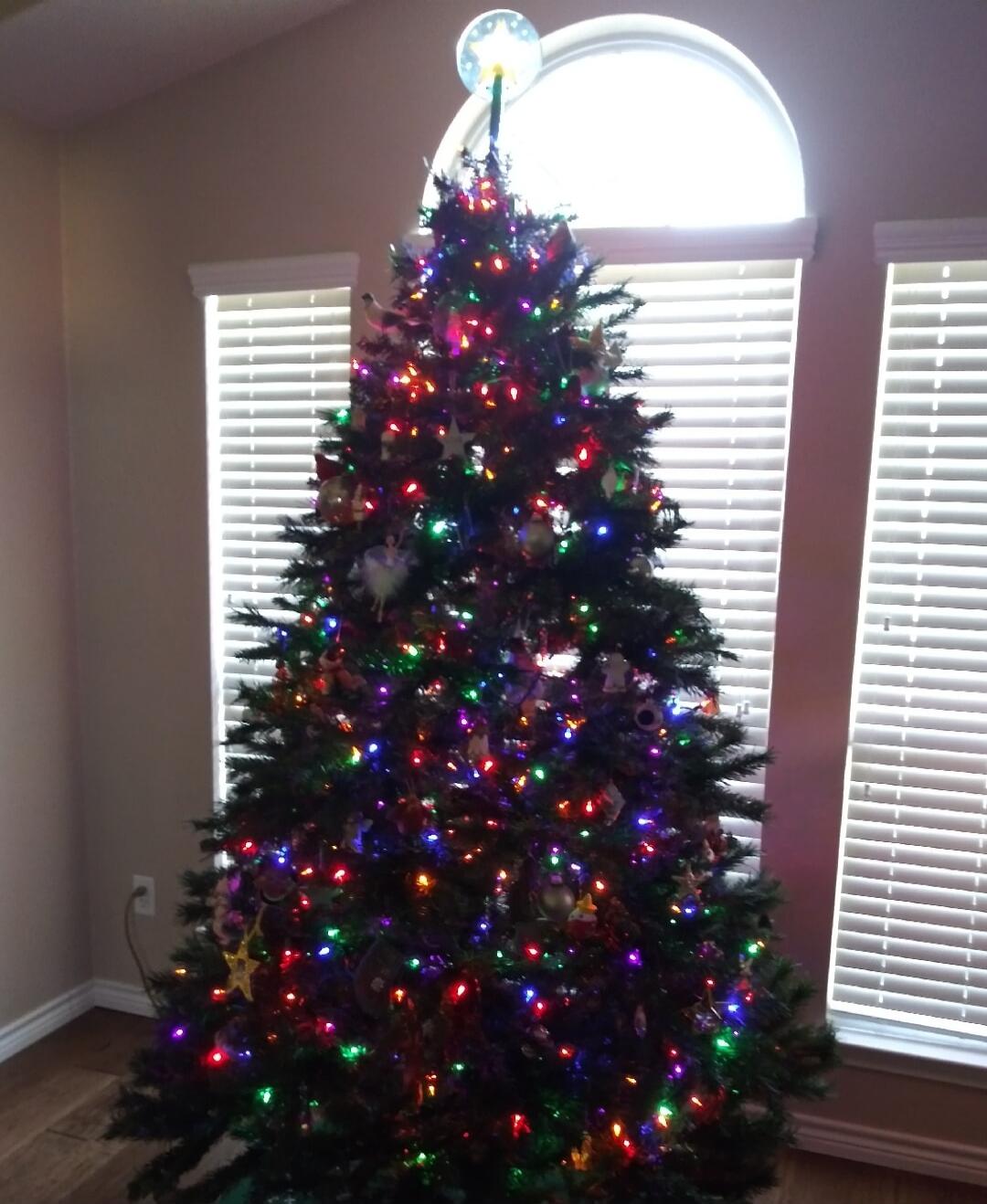 Christmas tree with multicolored lights in a living room.