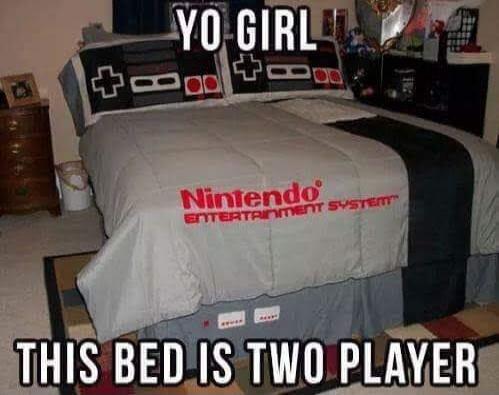 YO GIRL THIS BED IS TWO PLAYER. The bed features Nintendo Entertainment System themed bedding, including pillows designed like NES controllers and a duvet with 'Nintendo Entertainment System' written on it.