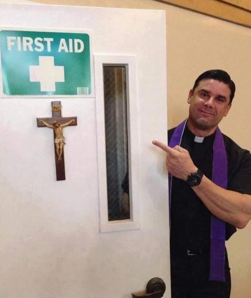 First Aid sign on a door with a crucifix; a priest in a purple stole points at the door.