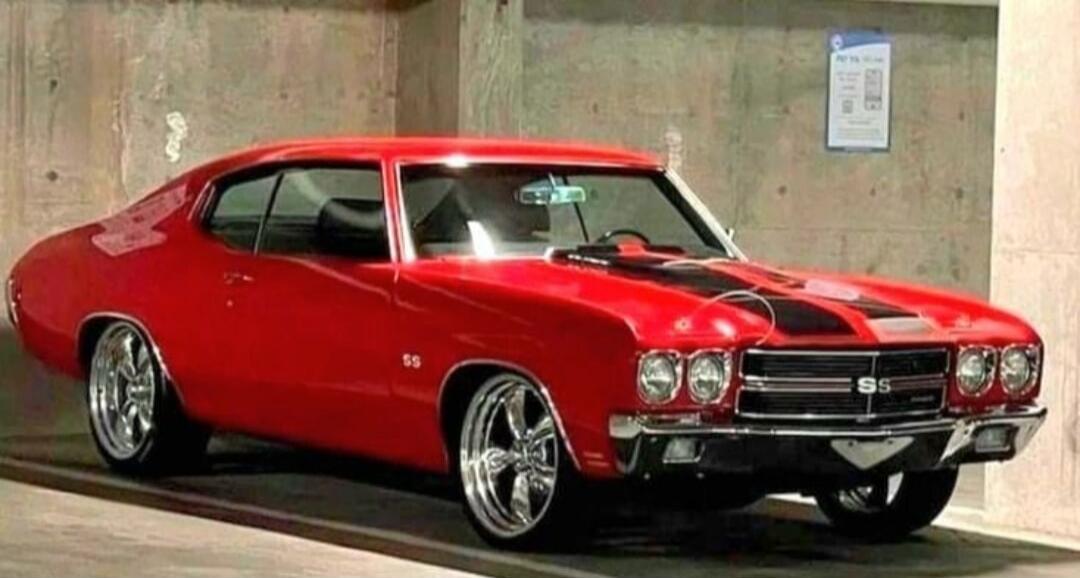 Red classic Chevrolet Chevelle SS muscle car with black racing stripes.