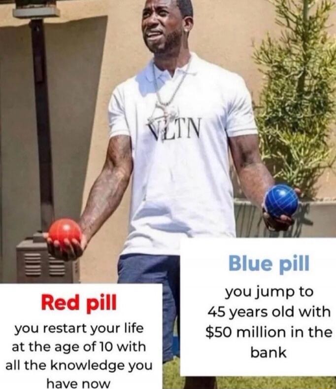 Gucci Mane wearing a VLTN shirt, holding a red ball and a blue ball. Text on the left says 'Red pill: you restart your life at the age of 10 with all the knowledge you have now'. Text on the right says 'Blue pill: you jump to 45 years old with $50 million in the bank'.