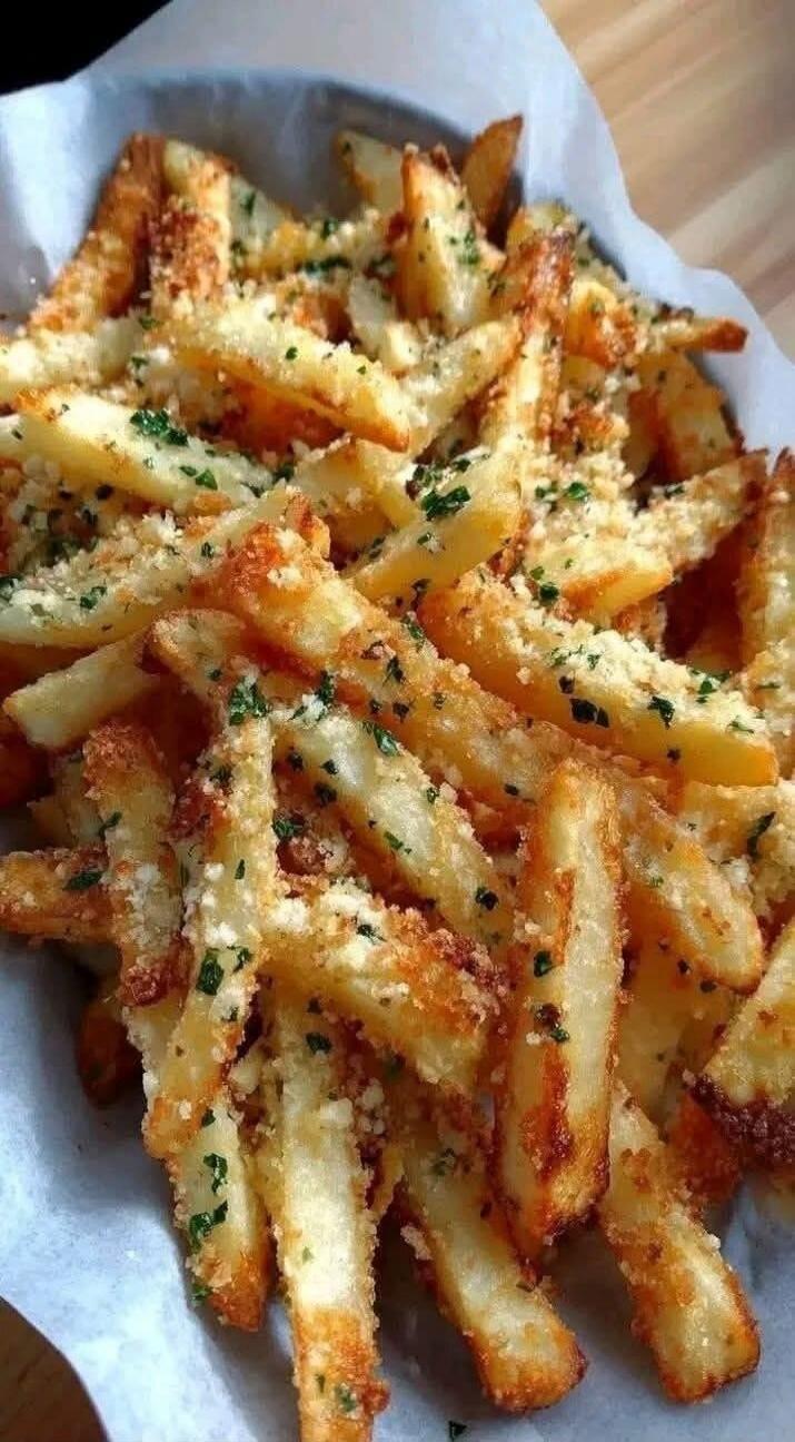 Fries topped with parmesan cheese and parsley, a crispy golden pile of seasoned potato sticks.