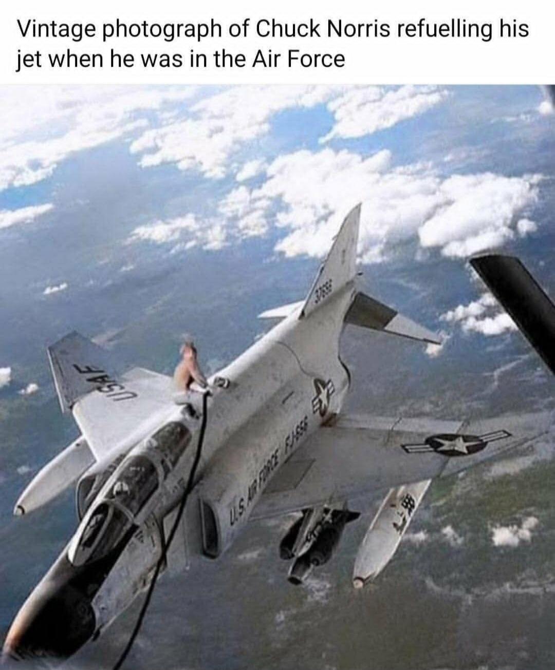 Vintage photograph of Chuck Norris refuelling his jet when he was in the Air Force. The image shows a man, presumably Chuck Norris, sitting on top of a fighter jet in mid-air, holding a fuel hose, implying he is manually refuelling the aircraft. The jet has 'USAF' and 'U.S. AIR FORCE' markings.