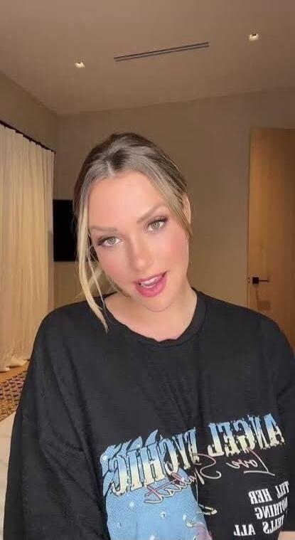 No speech detected. Text on shirt is mirrored and partially visible, appears to be 'ANGEL LACHIC' and other text.