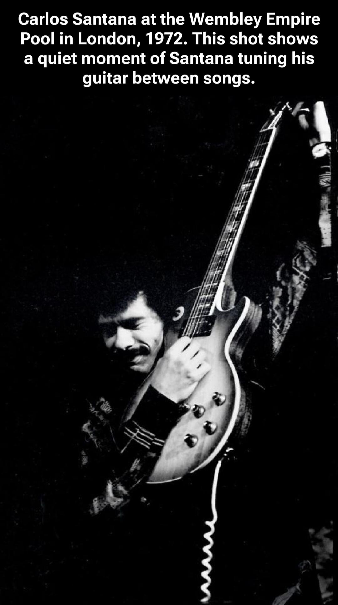 Carlos Santana at the Wembley Empire Pool in London, 1972. This shot shows a quiet moment of Santana tuning his guitar between songs.
