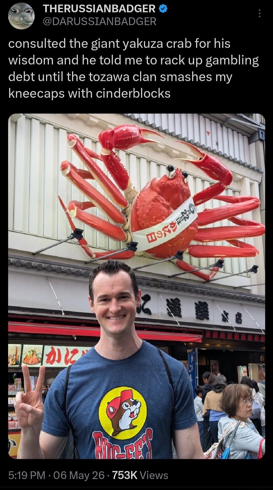 consulted the giant yakuza crab for his wisdom and he told me to rack up gambling debt until the tozawa clan smashes my kneecaps with cinderblocks. The building features a large crab sculpture with Japanese text '日の出かに' (Hinode Kani - Sunrise Crab). A man is smiling and making a peace sign in front of it.