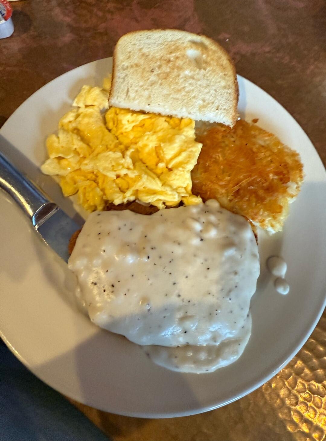 Toast, scrambled eggs, hash browns, chicken fried steak with white gravy