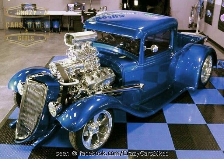 CRAZY CARS BIKES GIRLS seen @ facebook.com/CrazyCarsBikes A custom blue hot rod pickup truck with a large, exposed, supercharged engine is parked on a black and blue checkered floor.