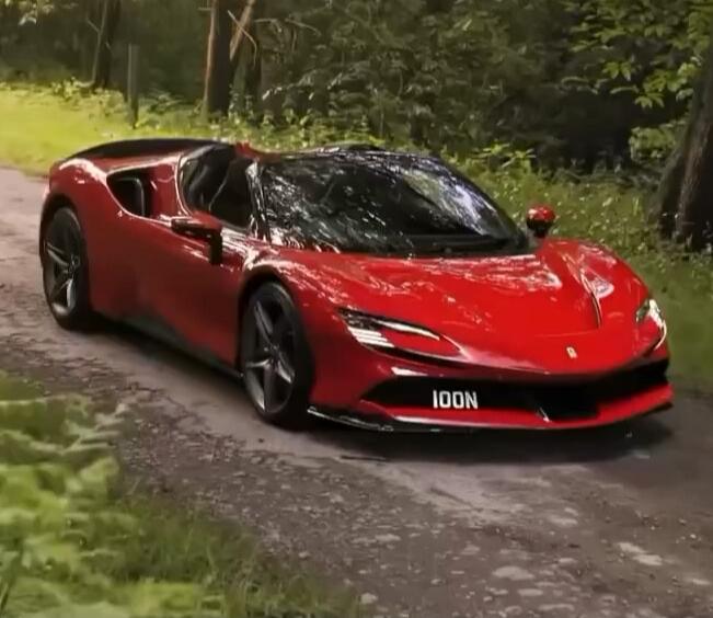 Red sports car on a forested road. The car has a sleek, low profile with a glossy finish. License plate reads '100N'.