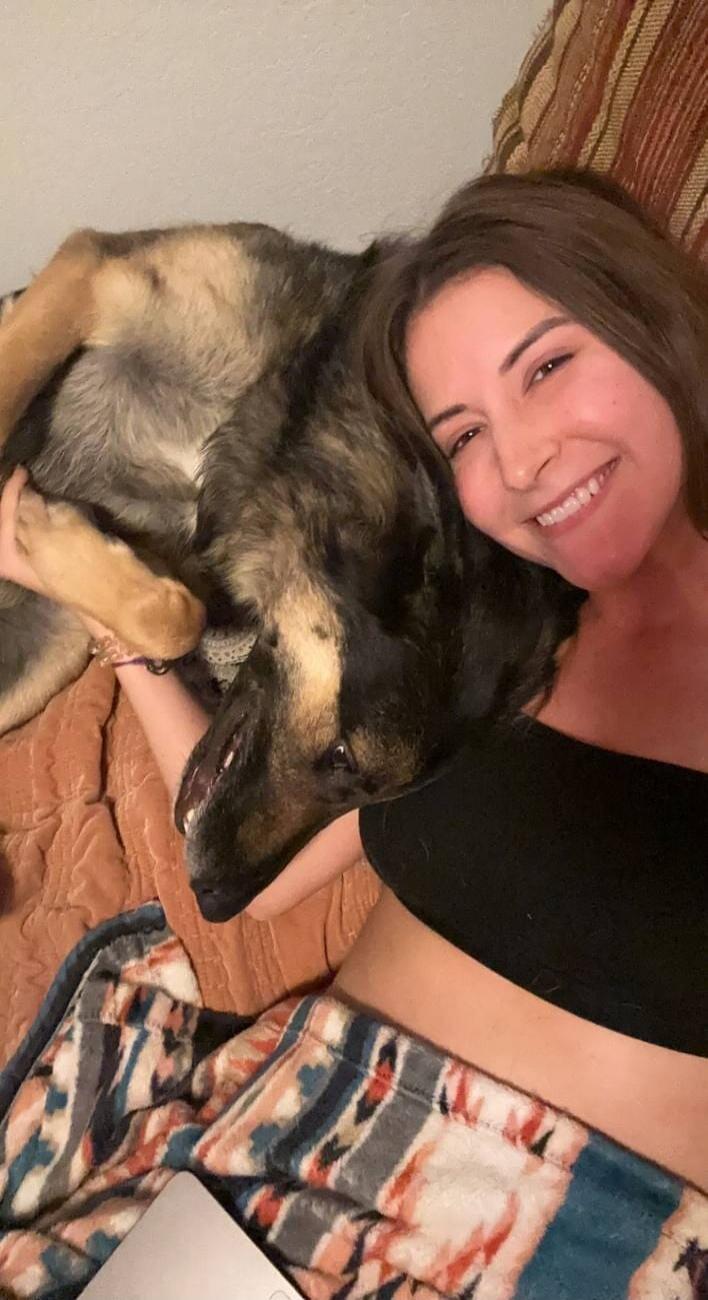 A woman and her dog cuddling on a couch.