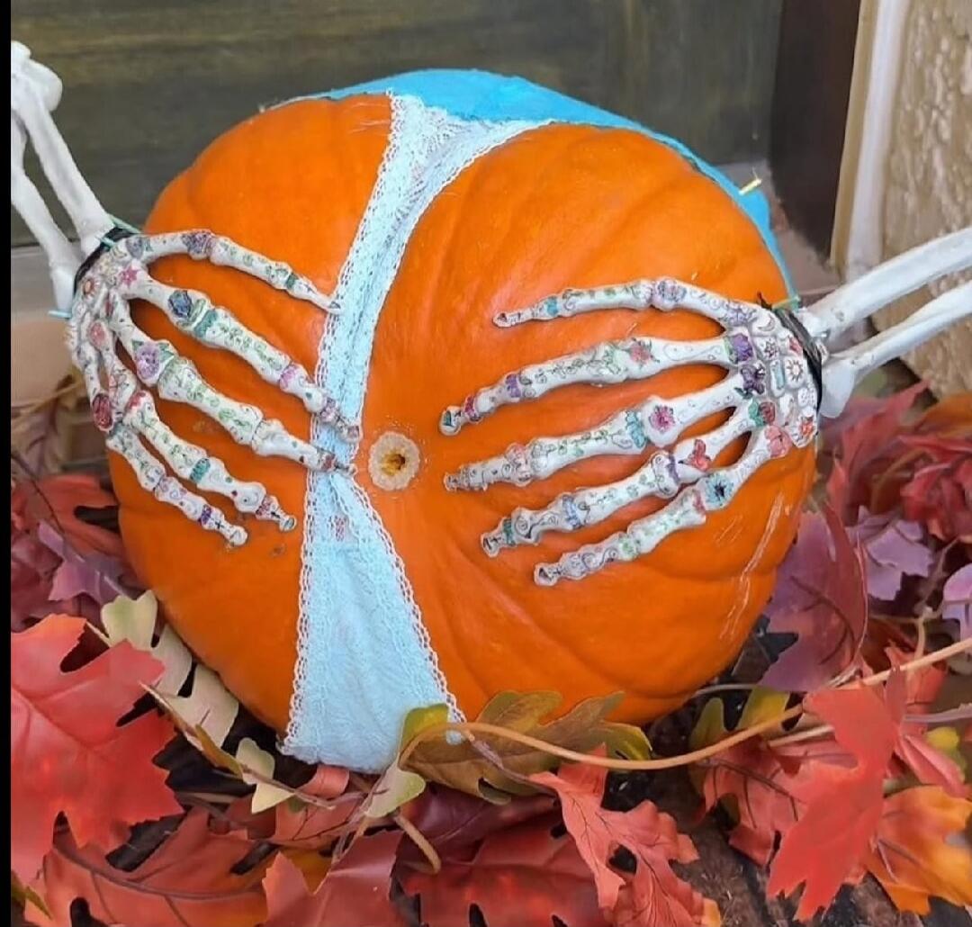 Halloween decorated pumpkin with skeletal hands
