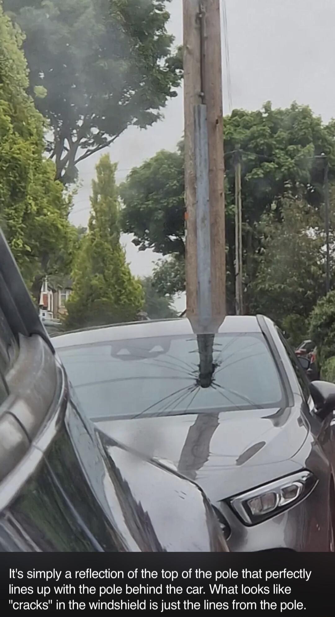 Its simply a reflection of the top of the pole that perfectly lines up with the pole behind the car What looks like cracks in the windshield is just the lines from the pole