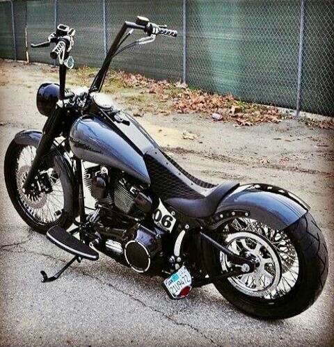 A black custom chopper motorcycle with a long front fork, raked stance, high handlebars, and a visible license plate.